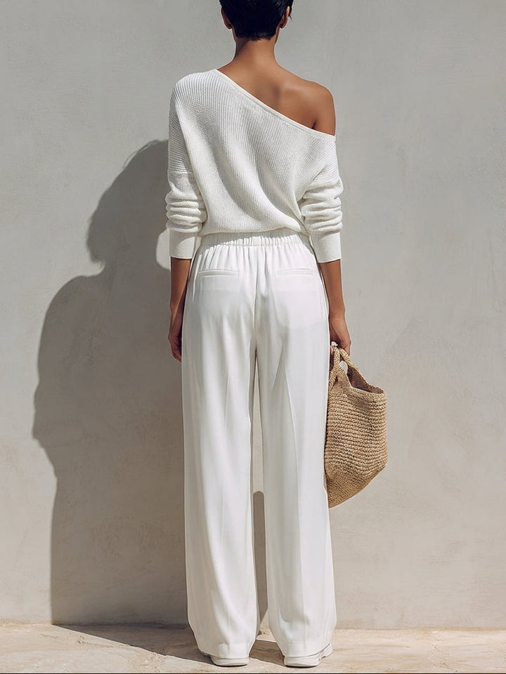 A woman wearing the Bennett and Lowe Adele two-piece set with a one-shoulder top and wide-leg pants in a stylish indoor setting.