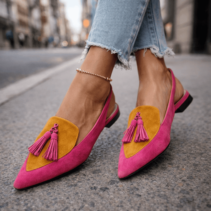 Eliza Bennett and Lowe handwoven tassel flat sandals with colorful tassels and leather straps on a neutral background
