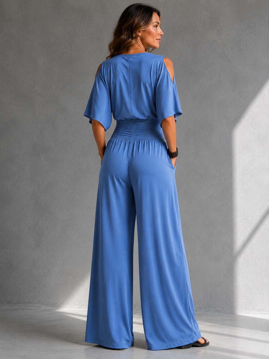 Bennett and Lowe Stella wrap V-neck jumpsuit in black, featuring long sleeves and a fitted waist, displayed on a hanger.