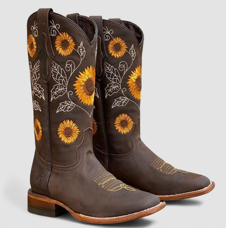 Women's cowboy boot by Bennett and Lowe featuring sunflower and daisy embroidery, with brown leather and decorative stitching.