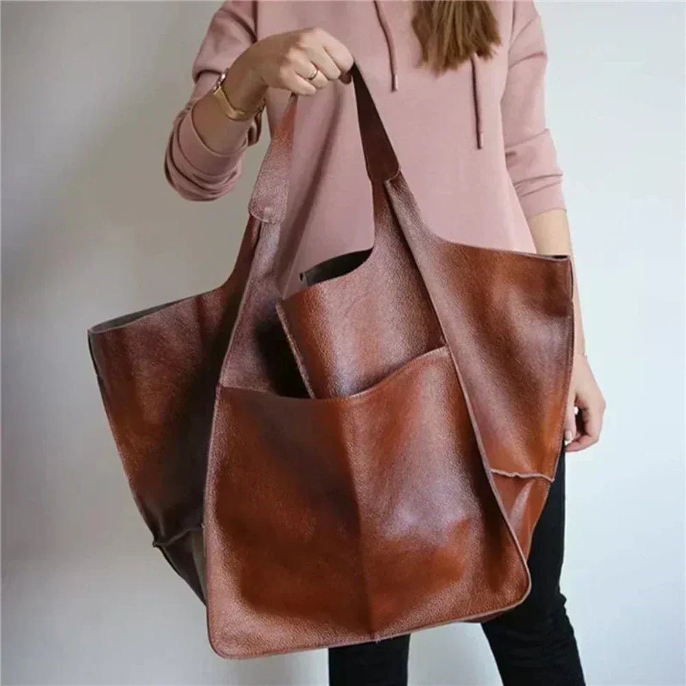Ruth Bennett and Lowe pebbled leather tote bag with adjustable strap, featuring sleek design and spacious interior.