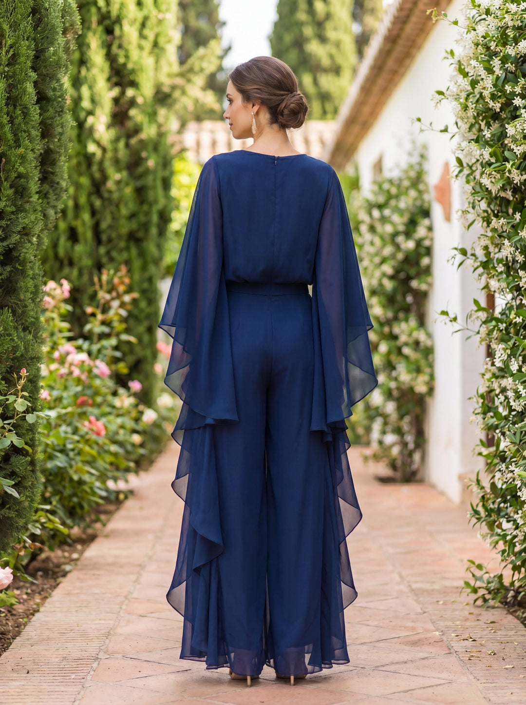 Woman wearing Lenorah cape-sleeve top and ruffled skirt two-piece set by Bennett and Lowe, stylish and elegant outfit.