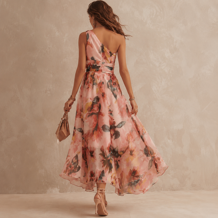 Back view of Bennett and Lowe Aurora one-shoulder floral dress featuring a flowing fabric and elegant floral pattern.