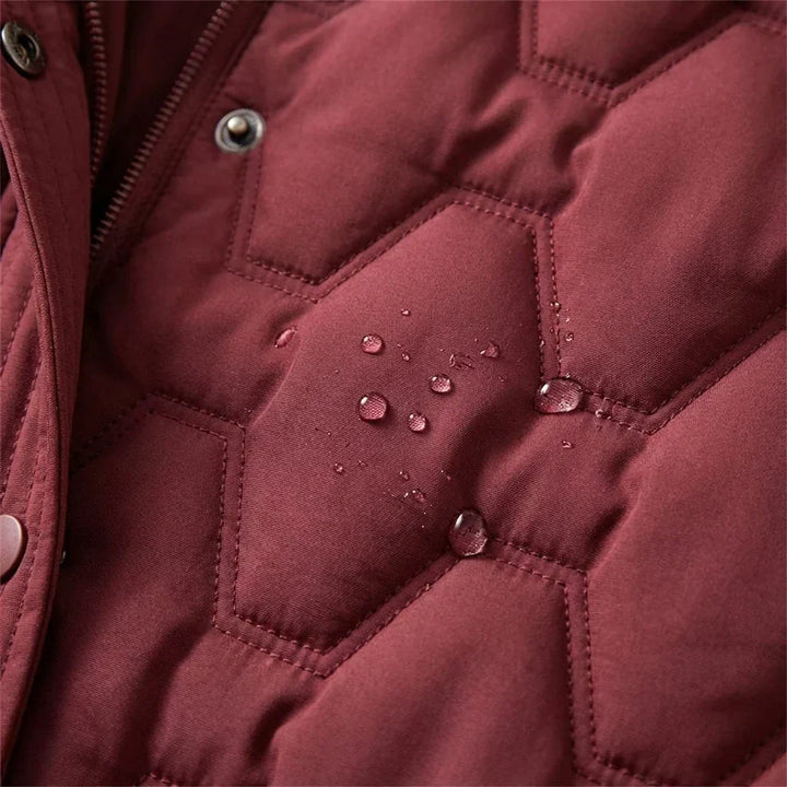Jacqueline Bennett & Lowe longline hooded quilted coat shown on a hanger, featuring a padded design and a hood for warmth and style.