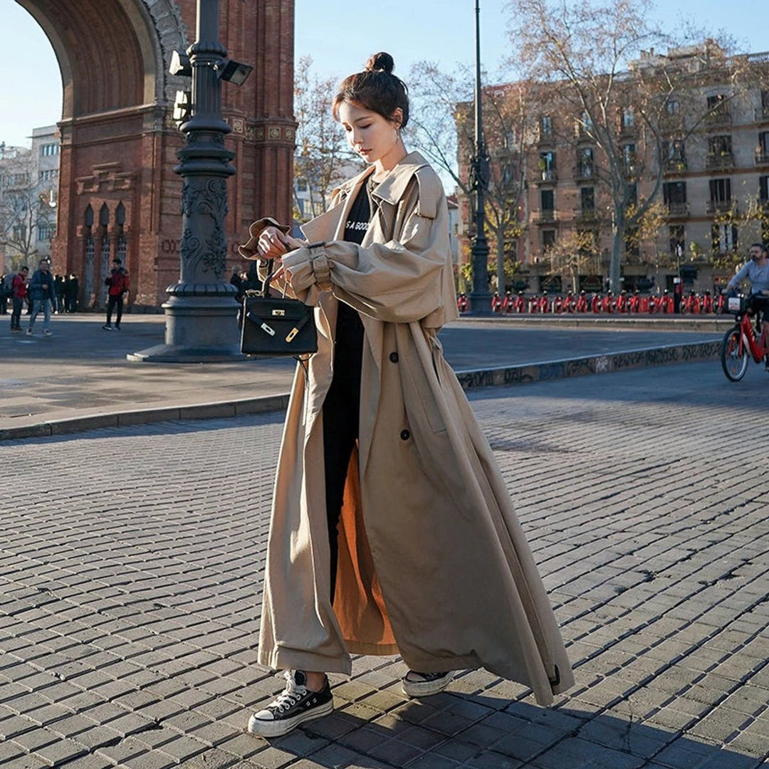 Women’s oversized double-breasted long trench coat by Bennett and Lowe, beige color, with wide lapels and belt details.